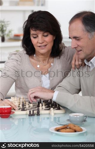 Couple playing chess together