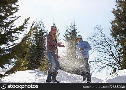 Couple playing in snow on hill