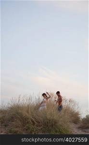 couple playing in the reed at the beach