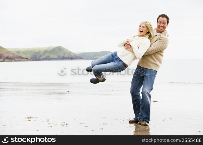 Couple playing on beach smiling