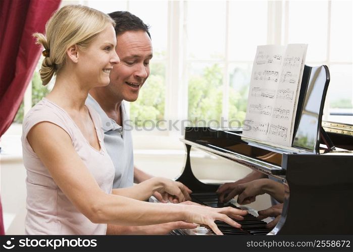 Couple playing piano and smiling