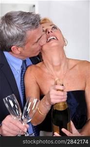 Couple popping a champagne cork