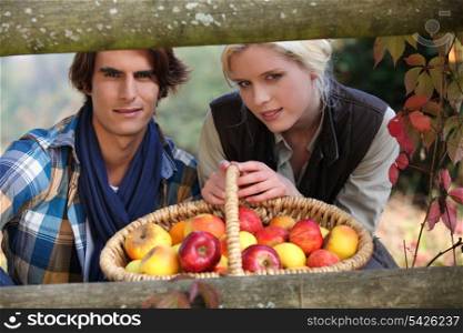 Couple posing behind wooden barrier