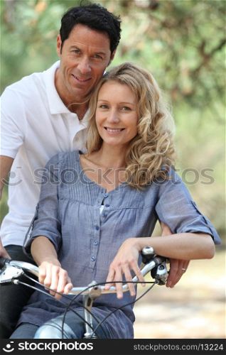 Couple posing by bicycle