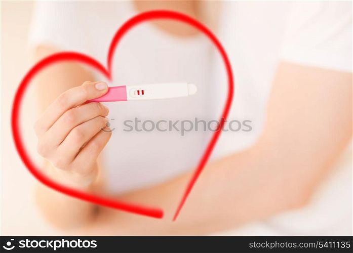 couple, pregnancy and love concept - close up of woman and man hands with pregnancy test