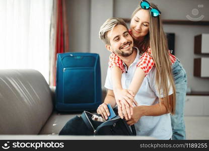 Couple prepares their bags and passports for vacation. Fees on journey concept. Luggage preparation. Couple prepares bags and passports for vacation