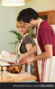 Couple preparing a meal together with the help of a cookbook