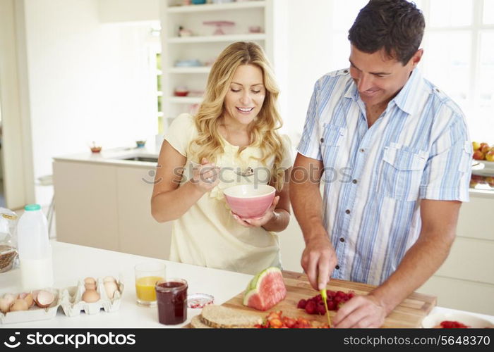 Couple Preparing Healthy Breakfast In Kitchen