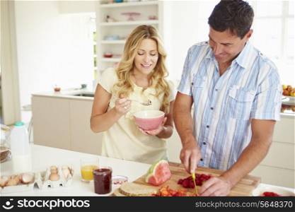 Couple Preparing Healthy Breakfast In Kitchen