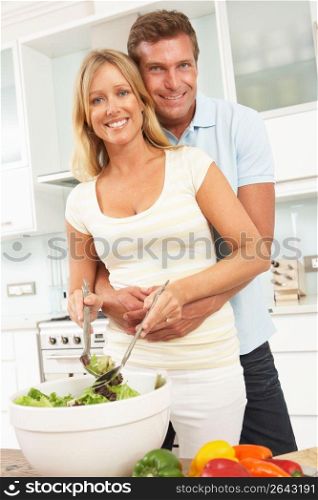 Couple Preparing Salad In Modern Kitchen