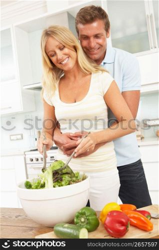 Couple Preparing Salad In Modern Kitchen