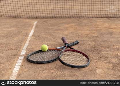 couple rackets with tennis ball ground