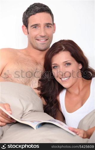 Couple reading a book in bed