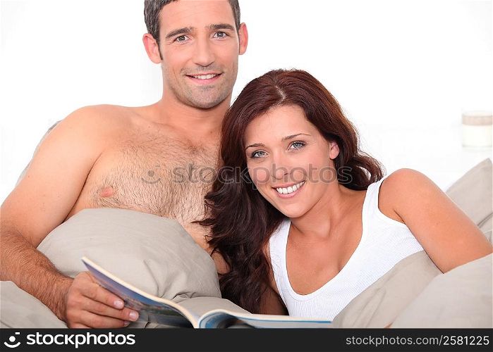 Couple reading a magazine in bed