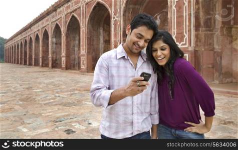 Couple reading an sms at Humayuns Tomb
