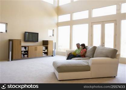 Couple reading book in living room