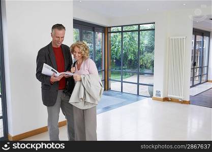 Couple Reading Brochure in New Home