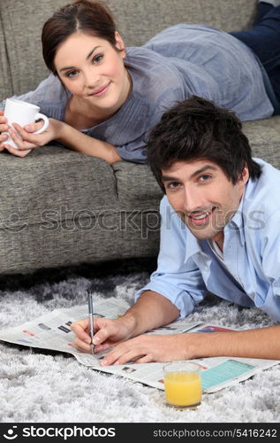 couple reading newspaper at home