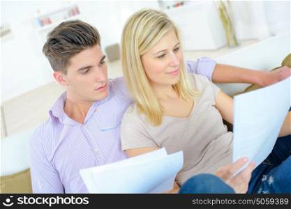 Couple reading through a contract on the sofa