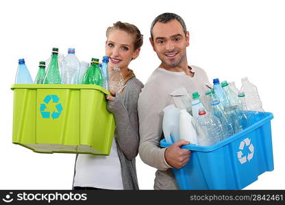 Couple recycling empty plastic bottles