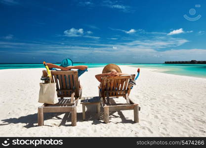 Couple relax on a tropical beach at Maldives