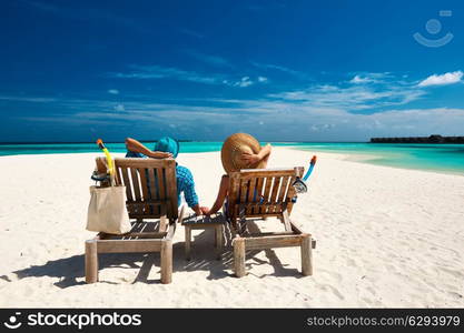 Couple relax on a tropical beach at Maldives