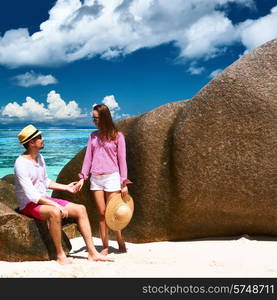 Couple relaxing among granite rocks on a tropical beach Anse Source d&rsquo;Argent at Seychelles, La Digue.