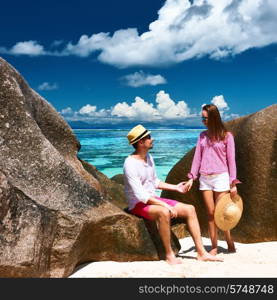 Couple relaxing among granite rocks on a tropical beach Anse Source d&rsquo;Argent at Seychelles, La Digue.