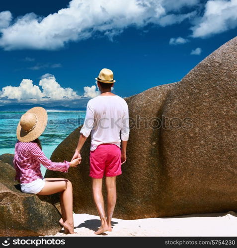 Couple relaxing among granite rocks on a tropical beach Anse Source d&rsquo;Argent at Seychelles, La Digue.