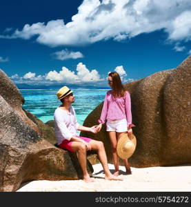 Couple relaxing among granite rocks on a tropical beach Anse Source d&rsquo;Argent at Seychelles, La Digue.