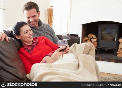 Couple Relaxing At Home Drinking Wine