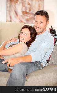 Couple relaxing at home in front of tv