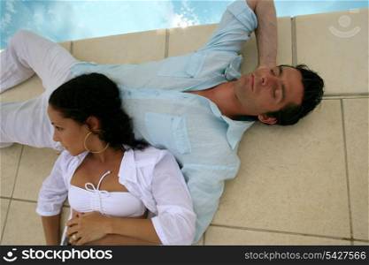 Couple relaxing by the pool