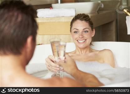 Couple Relaxing In Bath Drinking Champagne Together