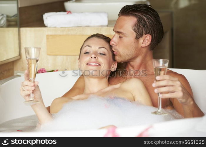 Couple Relaxing In Bath Drinking Champagne Together