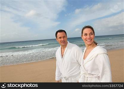 Couple relaxing in bathrobe at the beach