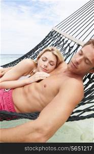 Couple Relaxing In Beach Hammock