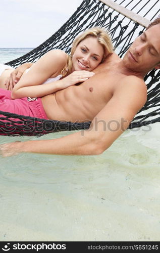 Couple Relaxing In Beach Hammock