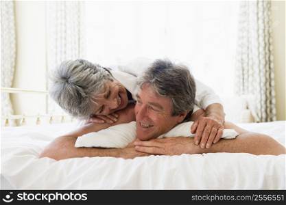 Couple relaxing in bedroom and smiling