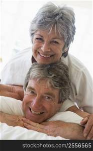Couple relaxing in bedroom and smiling