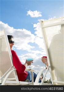 Couple relaxing in deckchairs rear view