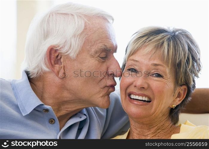 Couple relaxing in living room kissing and smiling