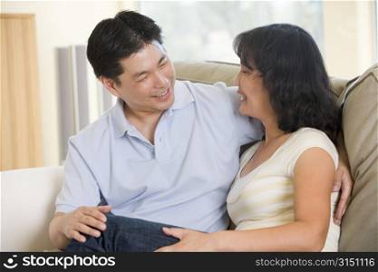 Couple relaxing in living room talking and smiling