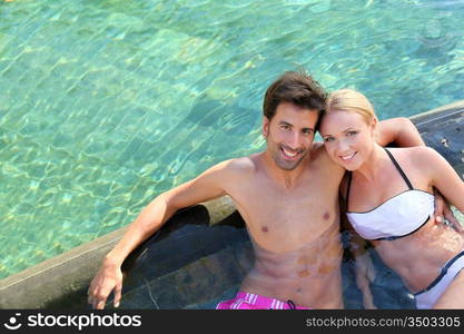 Couple relaxing in luxury hotel swimming-pool