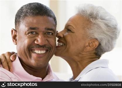 Couple relaxing indoors kissing and smiling