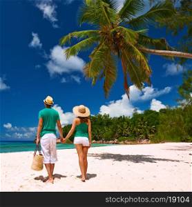 Couple relaxing on a tropical beach at Seychelles, La Digue.
