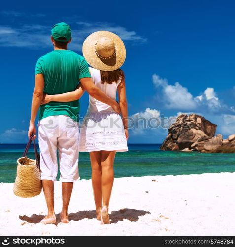 Couple relaxing on a tropical beach at Seychelles, La Digue.