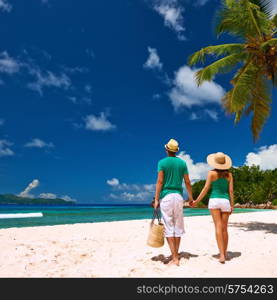 Couple relaxing on a tropical beach at Seychelles, La Digue.