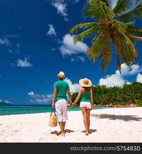 Couple relaxing on a tropical beach at Seychelles, La Digue.