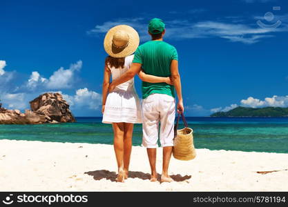 Couple relaxing on a tropical beach at Seychelles, La Digue.